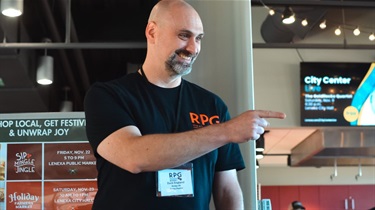 Man smiling while pointing at someone at gaming weekend
