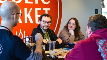 Group playing game at table and smiling at game lead