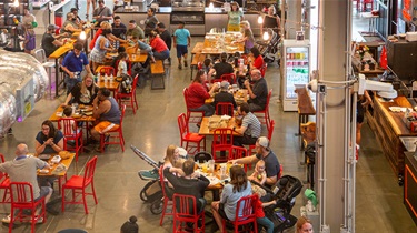 Families sitting at tables inside the Public Market main level