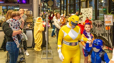 Kids and families dressed in Halloween costumes for indoor parade at the Public Market