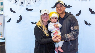 Public Market merchant owners of Saap Saap Noodles holding toddler child dressed up as a cup of noodlesh Public Market merchants from Saap Saap Noodles