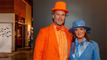 Man in orange tuxedo and woman in blue tuxedo for Halloween costume contest at Friday Night Sound Bites