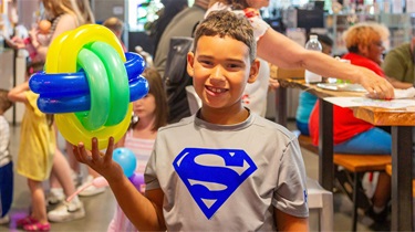 Boy smiling and holding balloon art