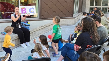 Librarian holding up a book showing letter 