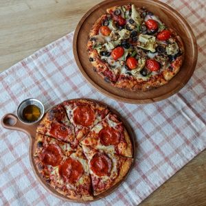 Hot Honey Pepperoni Pizza and The Gardener pizza on wooden table with fabric runner