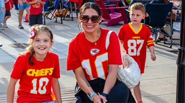 Woman and daughter wearing Kansas City Chiefs apparel and smiling outside the Public Market