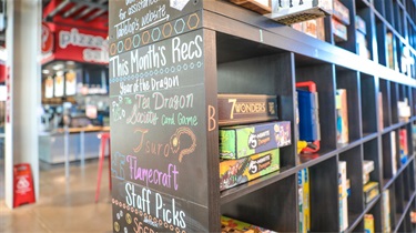 Wall of games displayed next to Cardboard Corner Cafe's stall