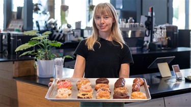 Mr. D's coffee employee holding large tray of donuts